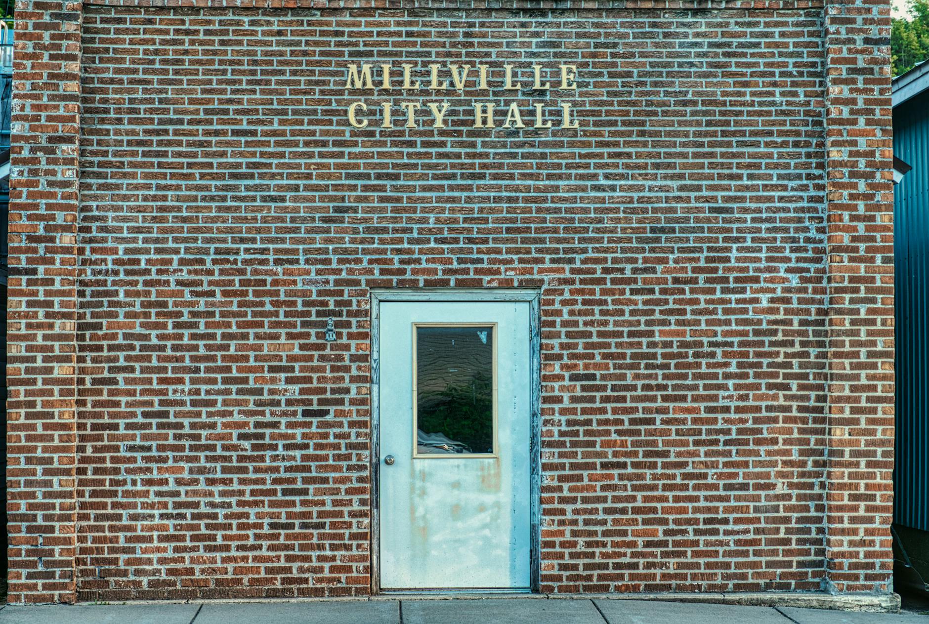 Front view of the brick facade and door of Millville City Hall in Minnesota.