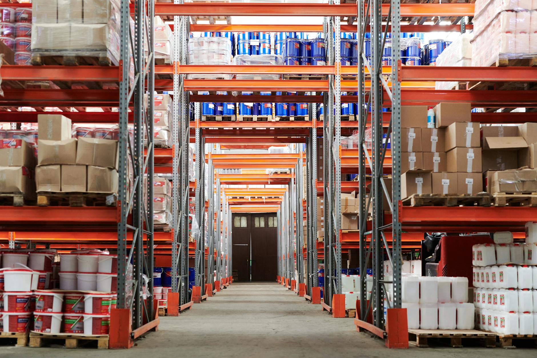 Wide angle view of a warehouse with stocked shelves and boxes.